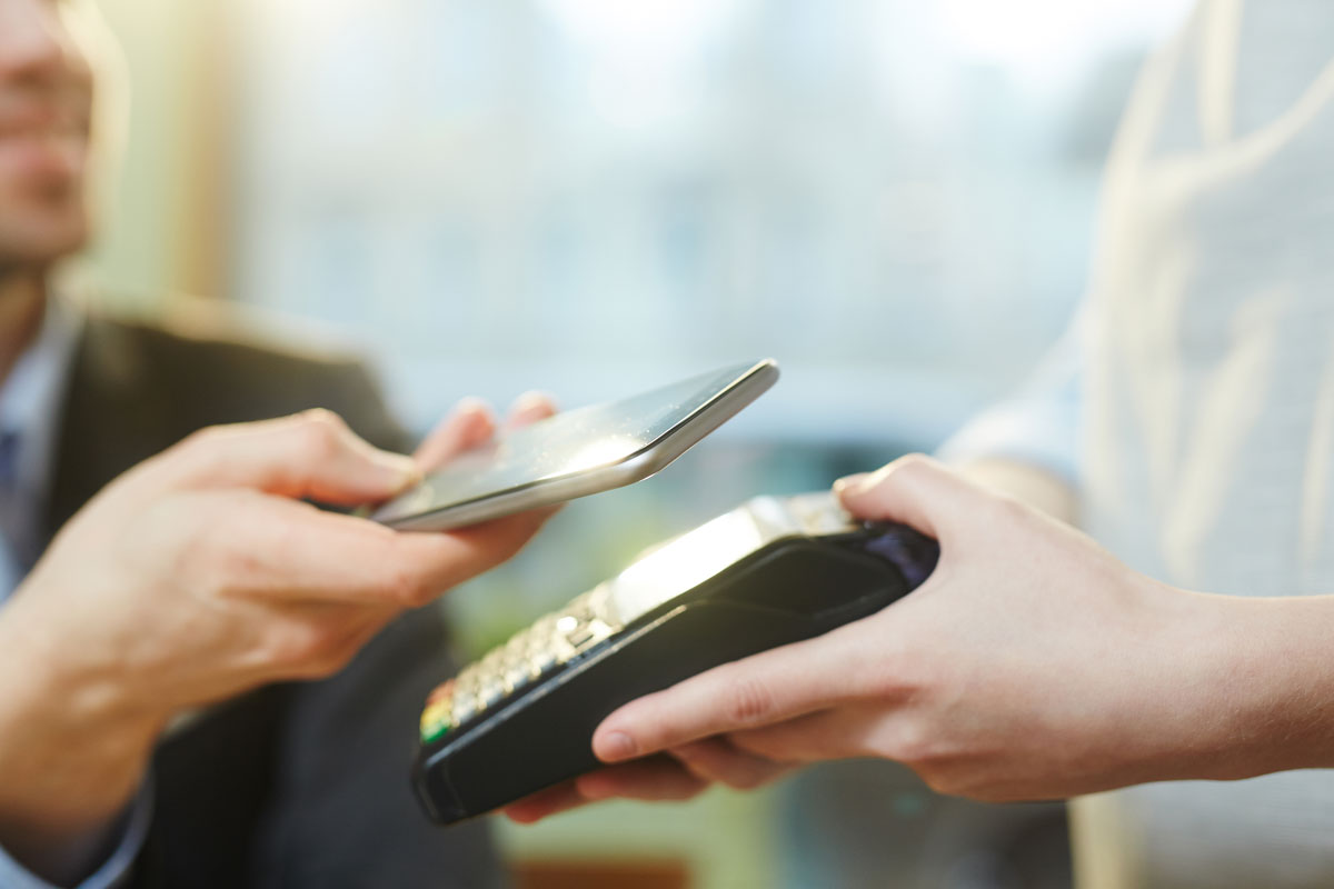 Customer using contactless payment in pub